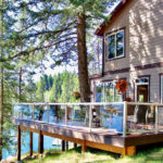 Two tone deck with glass railing on a lake.